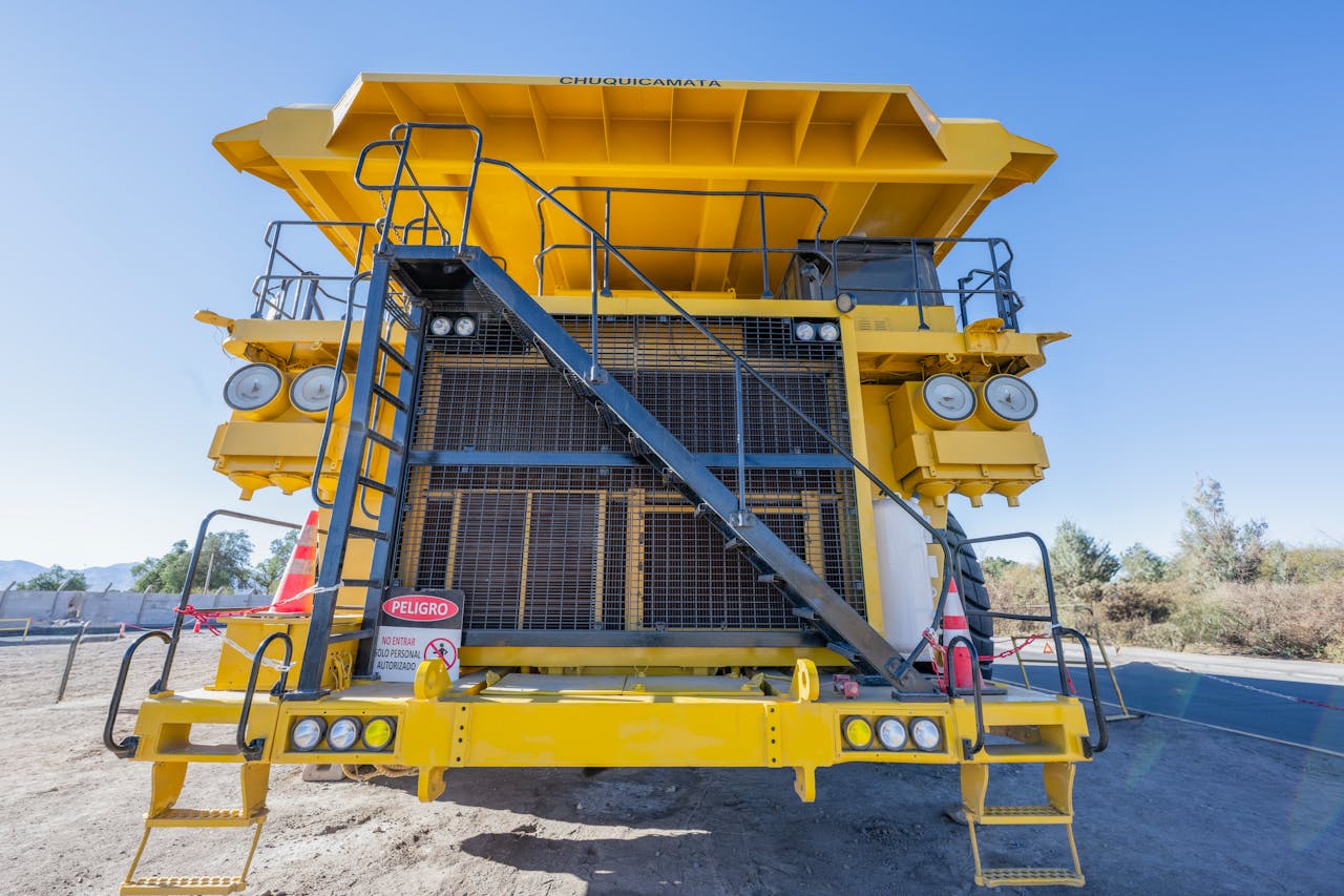 Front view of a large yellow mining truck in Chuquicamata mine, Calama, Chile, on a sunny day.